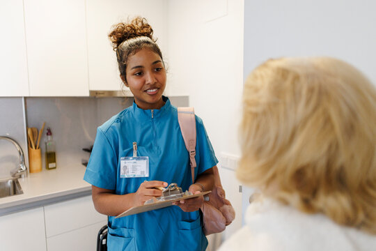 Nurse conducting healthcare checkup during home visit with patient