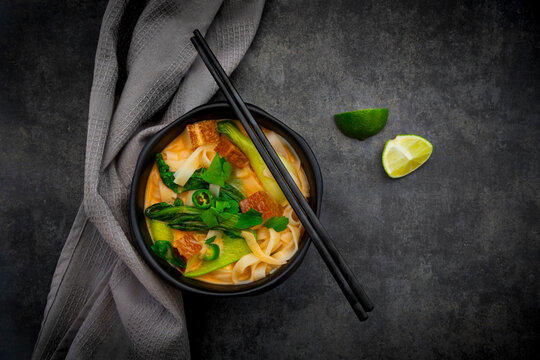 Red Thai curry soup with rice noodles smoked tofu pak choi and lime