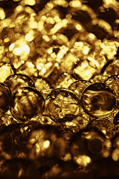 Abstract closeup of golden spherical bubbles and shiny background