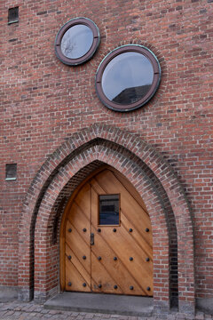 Residential brick architecture detail showing an arched door with apartment entrance character featuring facade texture and window elements on an urban building