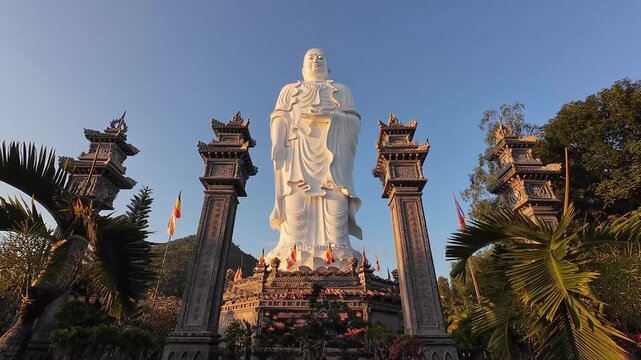 Standing Buddha statue at Tong Lam Son Temple in Nha Trang, Vietnam against a clear sky. Peaceful spiritual landmark with detailed sculpture and calm atmosphere.