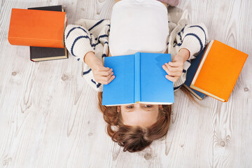 Cute girl reading colorful books. Learning and reading with fun - concept.