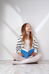 Cute girl reading colorful books. Learning and reading with fun - concept. Poster with copy space.