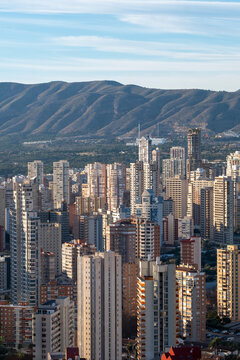 Highrise towers define the urban city skyline with mountains in Benidorm Valencia Spain captured in daylight with layered cityscape depth