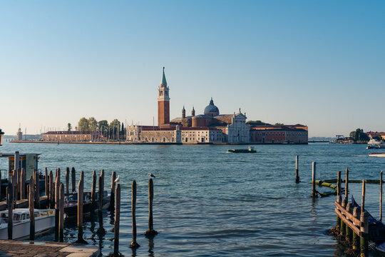 View of serene waters reflecting the architecture of the distant island, a mesmerizing blend of nature and civilization, Venice, Veneto, Italy.