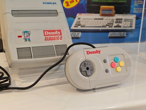 Russia, St. Petersburg, March 14, 2026 -Vintage Dendy video game console with controller displayed in a modern setting