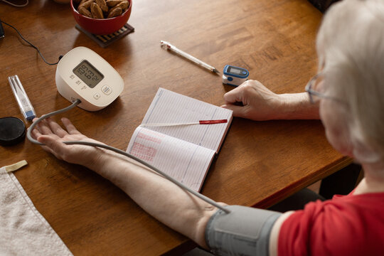 A pensioner monitors his blood pressure at home using a tonometer, hypertension and hypotension