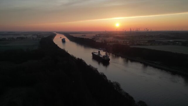 Schiffe fahren bei Sonnenaufgang im Nord-Ostsee-Kanal