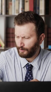 Pain in elbow. Vertical orientation of bearded man at computer workplace and experiencing pain and discomfort in elbow joint. Arthritis, orthrosis, bursitis concept