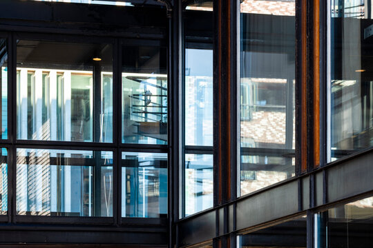 Modern building architecture with glass windows and frames showing urban reflection creating abstract structure and contemporary facade design detail background