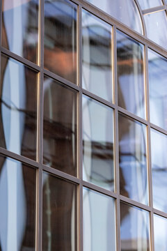 Glass building architecture windows with reflection and subtle distortion creating modern abstract grid pattern and clean urban facade geometry detail