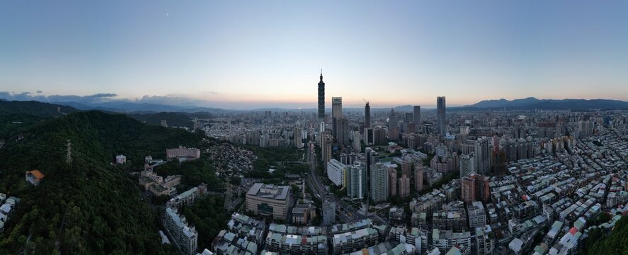 Taipei skyline and Taipei 101 at dusk under twilight sky.