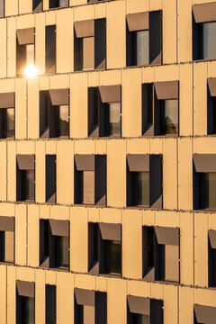 Sunlit urban architecture facade with windows pattern geometry texture and shadow contrast creating minimalism and repeating lines for modern background