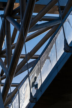 Modern architecture detail with steel beams structure and glass reflection showing diagonal geometry lines in daylight as abstract engineering design