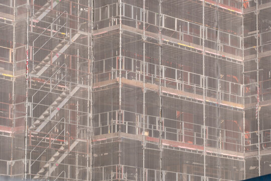 Urban renovation scene with scaffolding construction on building facade showing architecture pattern texture grid and layered structure detail