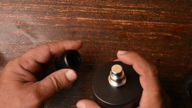 Perfume Spray Spraying into Bottle Cap &ndash; Close Up Top View Product Footage