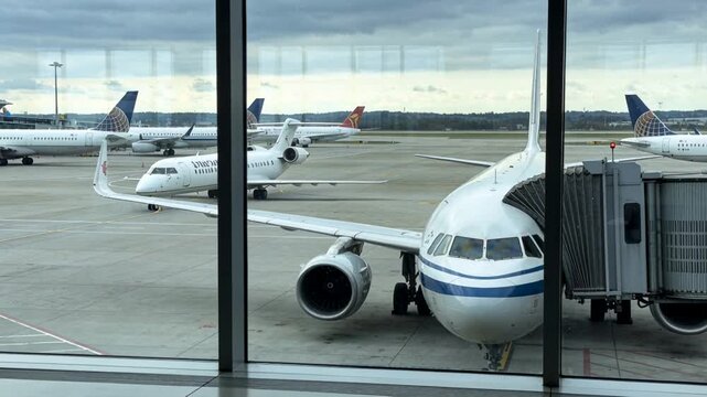 Narrowbody jet staying docked at gate jet bridge, twin-engine regional taxiing on ATC clearance