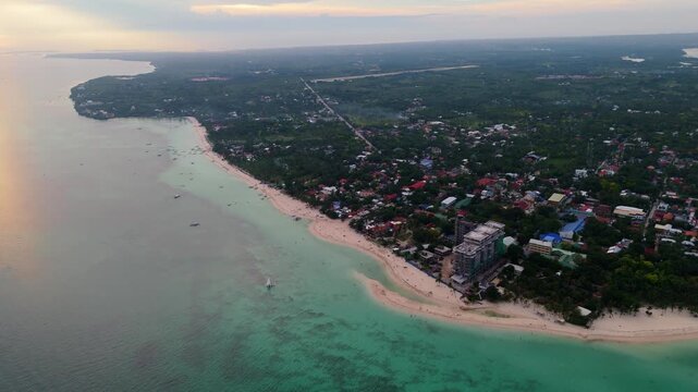 High-angle drone vista over Bantayan Island during twilight, showcasing the beautiful horizon and golden reflection on the water