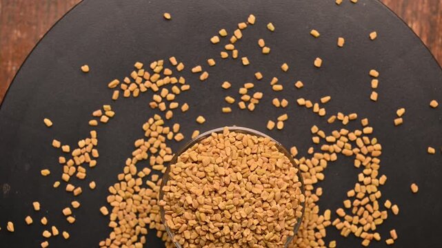 Top View of Methi Seeds (Fenugreek) in White Bowl on Black Background &ndash; Rotating Footage