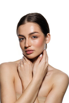 Natural beauty concept. Young woman with glowing clean skin smiling at camera on white studio background