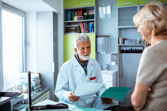 Senior doctor discussing test results with elderly patient in clinic