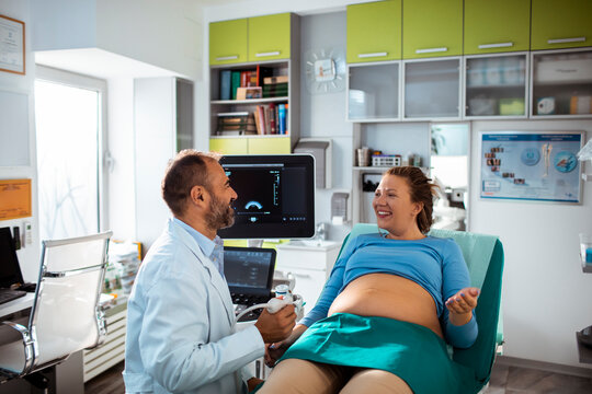Doctor performing prenatal ultrasound with pregnant woman in clinic