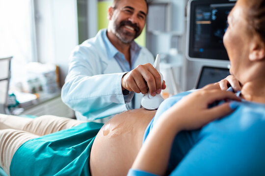Doctor performing prenatal ultrasound on pregnant woman in clinic