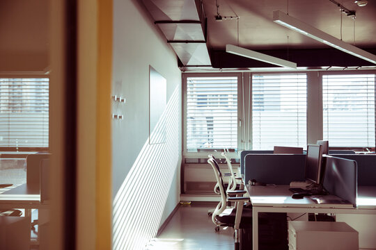 Empty corporate open plan office interior with sunlight through blinds