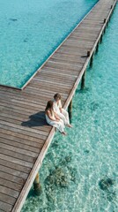 Fototapeta premium Two people, man and woman, sit on wooden pier facing each other over turquoise ocean water, serene moment, romantic, connection, tranquility, love., joyful connection, peaceful intimacy