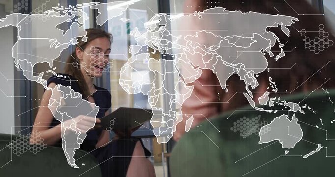 Interviewer asking question, candidate viewing tablet showing business data with world map overlay