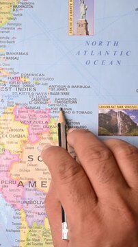 Male Hand Pointing Grenada on Map with Pencil &ndash; Top View, Vertical Footage