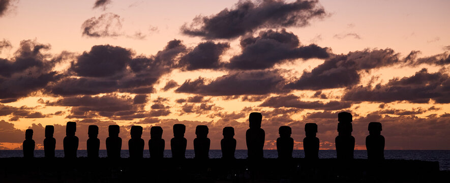 Silhouetten der Moai-Statuen auf der Osterinsel w&auml;hrend eines dramatischen Sonnenaufgangs.