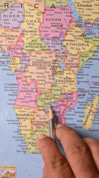 Male Hand Pointing Lusaka on Map with Pencil &ndash; Top View, Vertical Footage