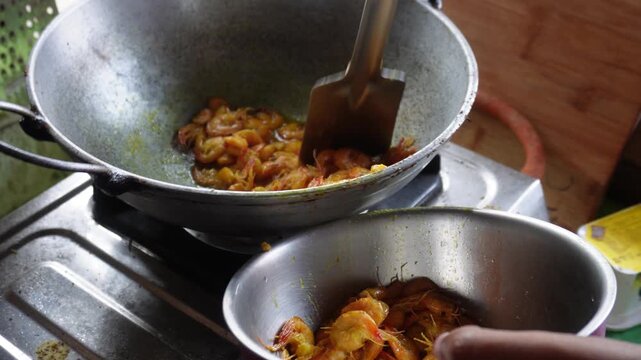 Fried Prawns Being Transferred from Kadai Pan to Bowl During Cooking Process