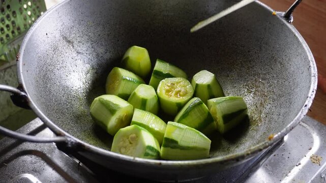 chopped pointed gourd Parwal or Potol frying on hot oil