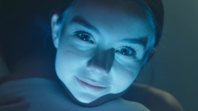 Gazing strapless female reacting to shifting studio gels, male leaning near left shoulder white tee