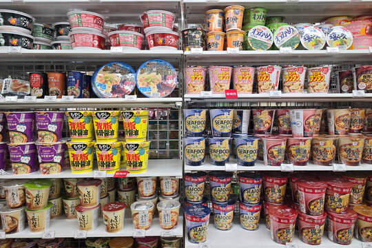 Oita, Japan - Jan 07, 2026: Various brands and flavors of instant cup ramen, seafood noodles, and miso soups neatly displayed on shelves at a 7-Eleven in Oita.