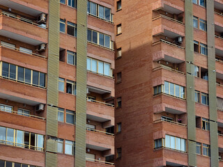 Fototapeta premium Modern red brick apartment building exterior, contemporary modern residential architecture in urban neighborhood in Valencia Spain
