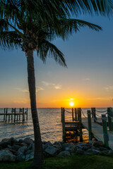 Fototapeta premium Boat pier and palm trees, sunset landscape on the Banana River in Cocoa Beach, Florida