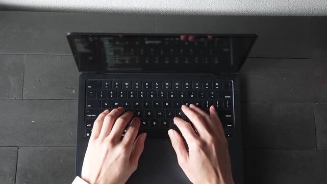 ノートパソコンをタイピングする手元 俯瞰 ビジネス リモートワーク 集中 / Close-up of hands typing on laptop keyboard, top view, remote work and productivity concept