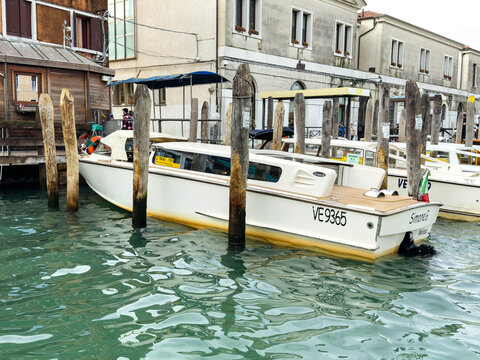 Venice, Italy - February 09, 2026: Motorboat named Simona docked at a wooden pier in a canal, surrounded by buildings and other boats in Venice, Italy