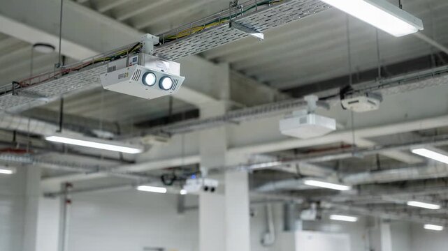 Medium shot of ceilingmounted sensor clusters capturing environmental data for heat and gas leak detection in a commercial facility highlighting comprehensive overhead hazard