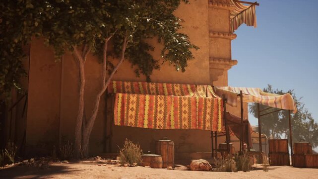 sunlit rug stall under fig tree, woven tapestries draped on wooden frame, pottery crates on sandy ground, adobe wall backdrop, warm midday shadows, quiet market
