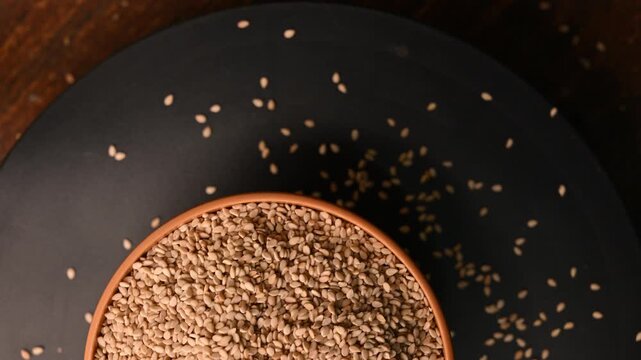 Top View of Urad Dal (Black Gram - Split Lentils) in White Bowl on Black Background &ndash; Rotating Footage