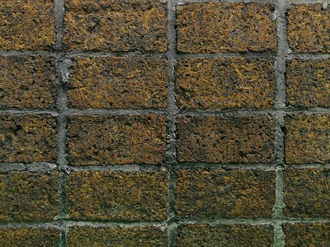 Old laterite stone brick wall background with porous texture