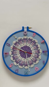 Time for craft and crochet. Vertical video of handmade clock with knitting and sewing accessories instead of numbers and lace doily for decorated dial. Hobbies and relaxation through needlework