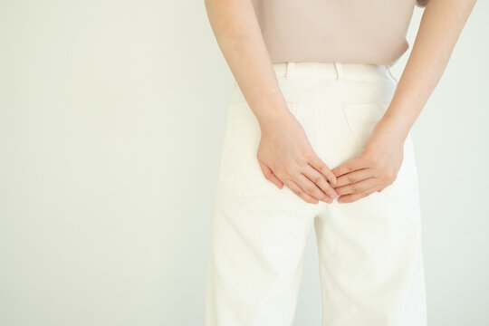 Woman suffering from anal pain and discomfort. Cause of pain include hemorrhoid, anal fissure, diarrhea, constipation or Crohn's disease. Gastrointestinal system concept.