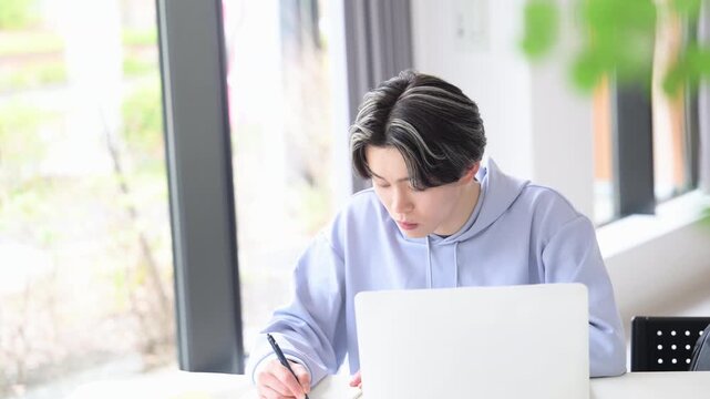 大学のキャンパスや予備校などの授業をうける大学生のような若い男性の教室や講義室で勉強する春や緑の爽やかなイメージ　ホワイトボードや正面を見上げるノートに書く動画