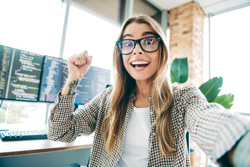 Excited female programmer celebrating a successful coding achievement in a bright modern home...