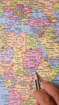 South Sudan highlighted on world map with pencil pointing to East Africa location - Vertical Video